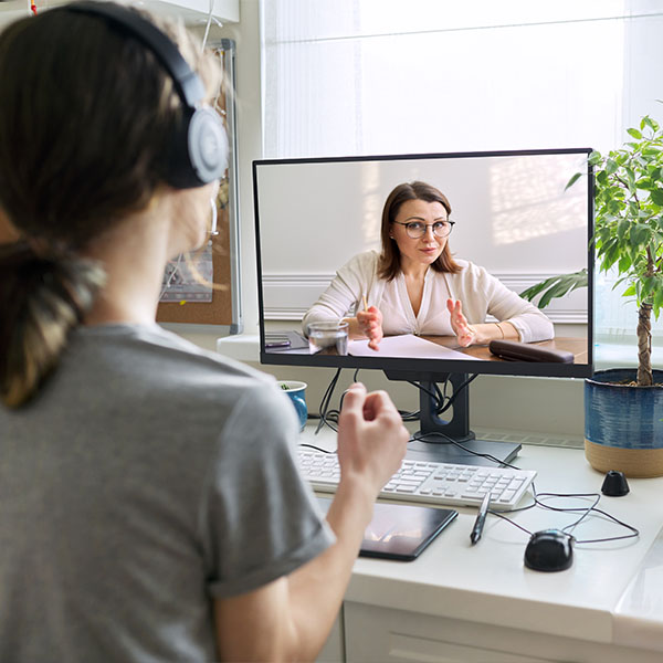 Kobieta w słuchawkach podczas sesji terapii online - psychoterapia indywidualna przez wideorozmowę z domu